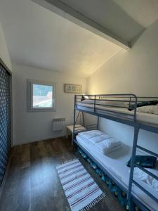 a room with two bunk beds and a window at Agréable maison au calme dans la pinède de Lacanau in Lacanau