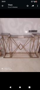a glass table with two metal legs on a table at Duplex mignant in Fez