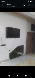 een flatscreen-tv aan een muur bij Duplex mignant in Fès
