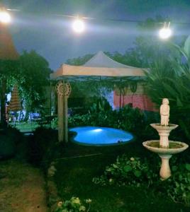 un jardín con una fuente y un cenador por la noche en Casargentina Apart Depto entero Baño privado 15min Ezeiza en Monte Grande