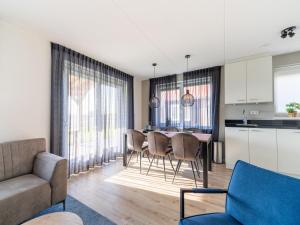 cocina y sala de estar con mesa y sillas en Modern holiday home in Scherpenisse with garden, en Scherpenisse