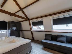 ein Schlafzimmer mit einem Bett und einem Sofa darin in der Unterkunft Beautiful apartment on the first floor Abcoude in Abcoude