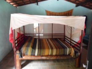 a bed with a canopy in a room at Nas matas da lagoa Azul in Cruz