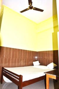 - une chambre avec un lit et un ventilateur de plafond dans l'établissement Hotel Kaushalya Residency Inn Uttarakhand Near By Gandhi Park - Family-friendly, à Berināg