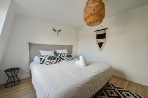 um quarto com uma cama com duas almofadas em La Casa Blanca - 6 personnes proche Disney & Paris em Le Raincy