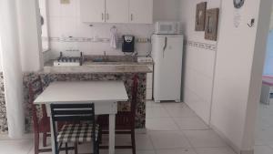 a small kitchen with a counter and a refrigerator at Apartamento Vento e mar - 2 quartos com sacada na quadra da praia com sauna a vapor in Santos