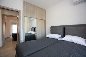 a bedroom with two beds and a mirror at SoL Apt Faliraki in Faliraki