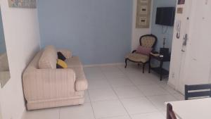 a living room with a couch and two chairs at Apartamento Vento e mar - 2 quartos com sacada na quadra da praia com sauna a vapor in Santos