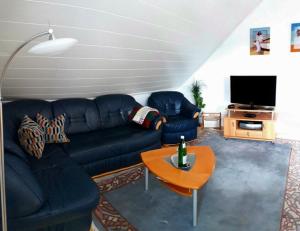 a living room with a blue couch and a table at Ferienwohnung Maria Miller in Hemfurth-Edersee