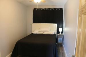 a bedroom with a bed with a black blanket and a window at Small House, 2 queen bedrooms, 1 bath, on route 33 in Nelsonville