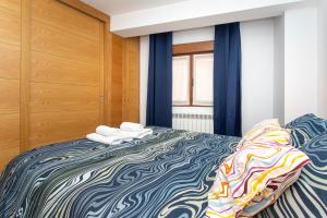 Un dormitorio con una cama grande con cortinas azules. en La Plaza de Cangas Apartamento Turistico, en Cangas de Onís