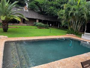 a large swimming pool in a yard with a yard at Khandizwe Kruger Villa in Malelane