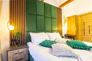 Schlafzimmer mit einem Bett mit grünen und weißen Kissen in der Unterkunft Doza de Verde Chalet Bran in Sohodol