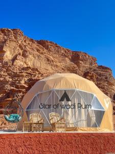 a tent with chairs in front of a mountain at STAR of Wadi Rum in Wadi Rum