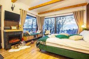 a bedroom with a large bed and a fireplace at Doza de Verde Chalet Bran in Sohodol