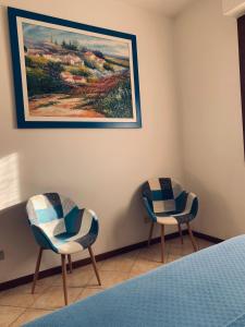 two chairs in a room with a painting on the wall at Dom a Verona in Verona