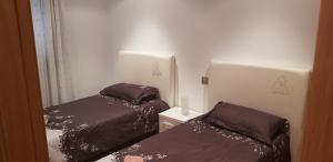 two beds in a small room with two bedsskirts at Centro Viveiro in Viveiro
