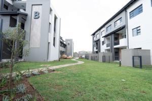 ein Gebäude mit einem Rasenplatz vor einem Gebäude in der Unterkunft Fourways Oasis in Sandton