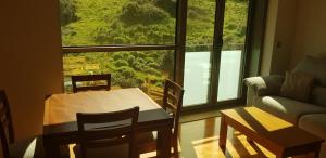 a living room with a table and a couch and a window at Centro Viveiro in Viveiro