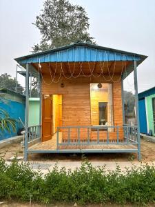 a small house with a blue roof at Farm with 5 huts, heated pool and bonfire in Gurgaon