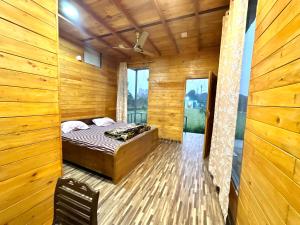 a bedroom with a bed in a room with wooden walls at Farm with 5 huts, heated pool and bonfire in Gurgaon