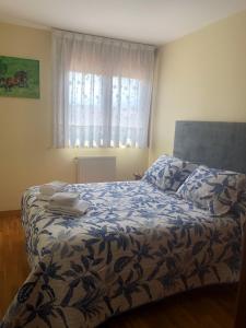 1 dormitorio con 1 cama con manta azul y ventana en APARTAMENTO RIO SELLA en Arriondas