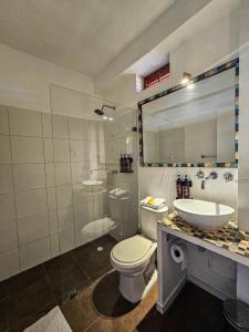 a bathroom with a toilet and a sink and a shower at El Beso Rooms in Cartagena de Indias