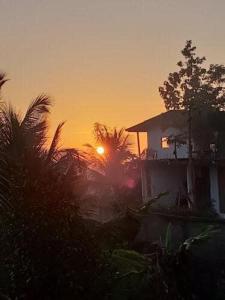 uma casa com o pôr do sol no fundo em Mountain View em Kandy