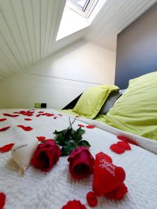Una cama con pétalos de rosa roja. en Bienvenue dans le chartreuse 2 à 6 couchages, en Cholonge