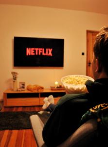 a person sitting on a couch watching a television at Pokrzepka in Spychowo