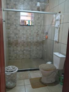 y baño con ducha y aseo. en Chácara Paraíso, en Pouso Alto