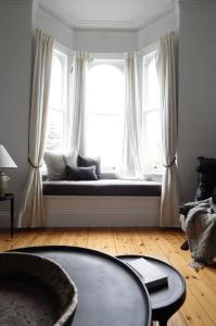 a living room with a large window with a window seat at The Cobbler in Royal Park