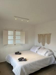 un letto bianco con due scarpe sopra di Casa Plaza 2 a Vega de Río de Palmas