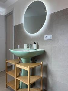 un bagno con un lavandino verde e uno specchio di Casa Plaza 2 a Vega de Río de Palmas