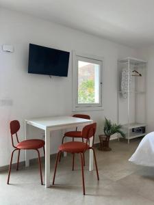 un tavolo bianco e due sedie rosse in una stanza di Casa Plaza 2 a Vega de Río de Palmas