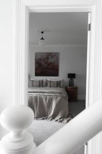 a bedroom with a bed in a white room at The Cobbler in Royal Park