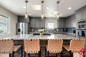 a kitchen with a large island with chairs around it at Desert Skyline Getaway - An Irvie Home in Tijeras