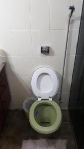 a bathroom with a green and white toilet in a stall at Quarto Quádruplo in São Pedro