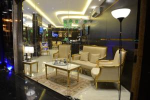 a living room with a couch and a table and chairs at ليالي العاذريه للشقق المخدومة in Al Namas