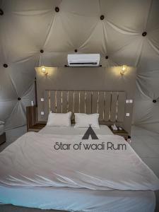 a bed in a tent with a sign that says star of wear run at STAR of Wadi Rum in Wadi Rum