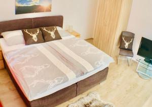 um quarto com uma cama com um cobertor e uma cadeira em Alpen Appartements Oberlehengut - HIDEAWAY em Werfenweng