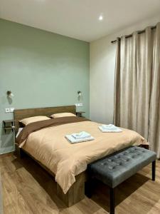 Schlafzimmer mit einem großen Bett und einer Bank in der Unterkunft One Fine Stay in Piräus