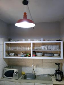 - une cuisine avec un évier et une lumière dans l'établissement Appart F2 Lomé centre, à Lomé