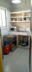 Il comprend une petite cuisine équipée d'un évier et d'une cuisinière. dans l'établissement Appart F2 Lomé centre, à Lomé