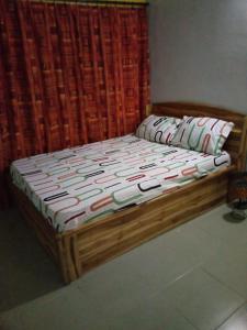 a bed with a wooden frame in a room at Appart F2 Lomé centre in Lomé