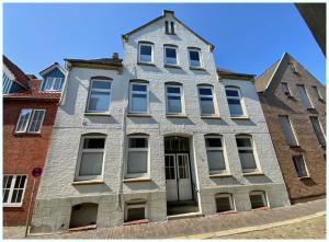 an old house with a turret on a street at Apartment No.9 in Husum