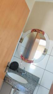 Pousada Apucarana في أبوكارانا: حمام به مرآة وقطة على الأرض