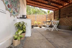 a patio with a table and a table and chairs at Casa aloha in Atins
