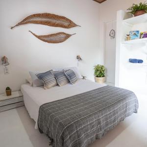 a white bedroom with a bed with a gray blanket at Casa aloha in Atins
