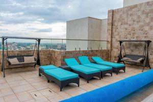 a patio with blue cushioned chairs on a roof at Luxe Romance Retreat for Couples in Nairobi